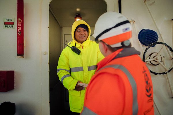 A Stella Maris port chaplain is welcomed aboard a docked ship.